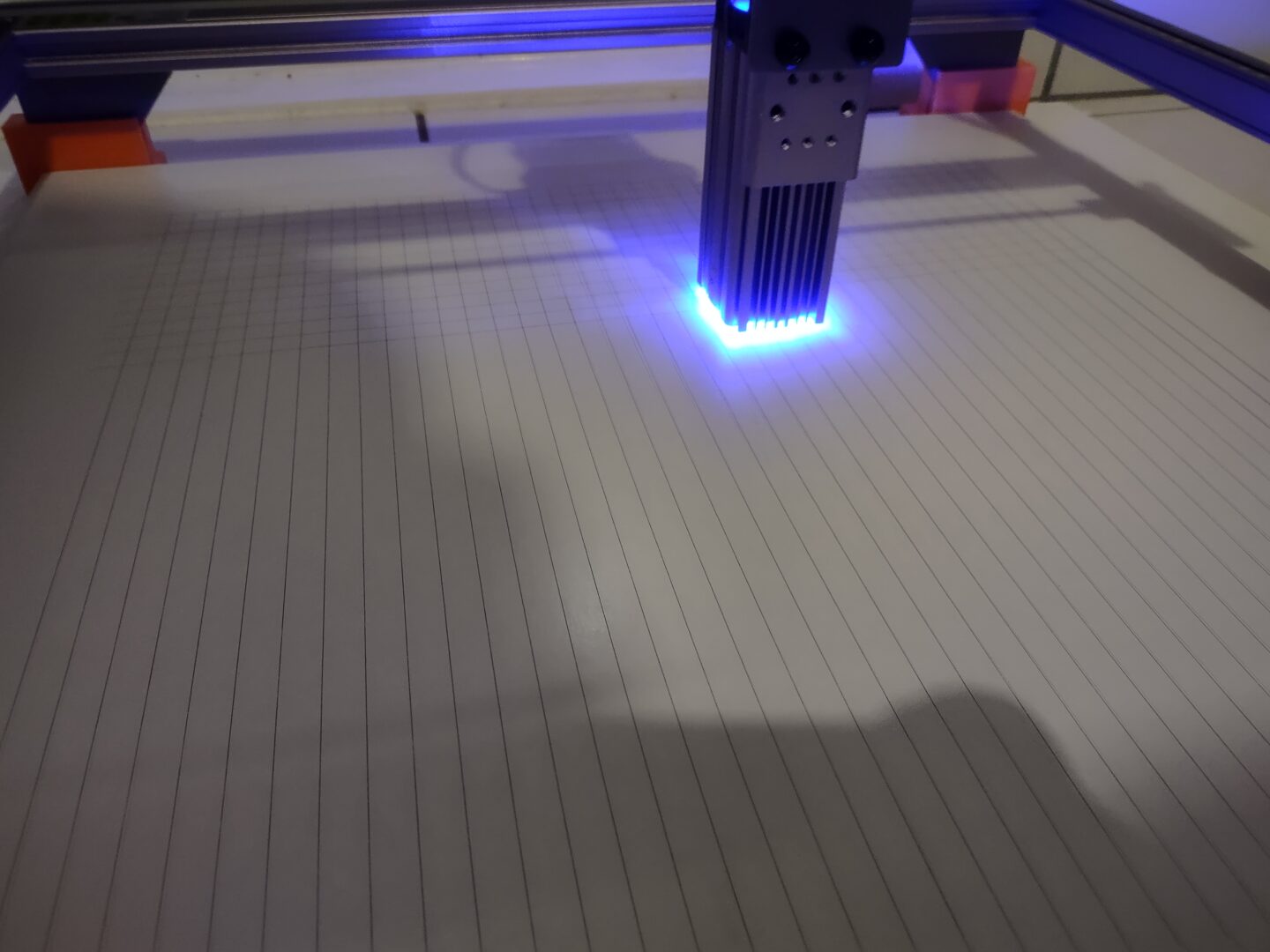 Eine weiße Platte mit ein paar wenigen Linien, über die ein Laser fährt.