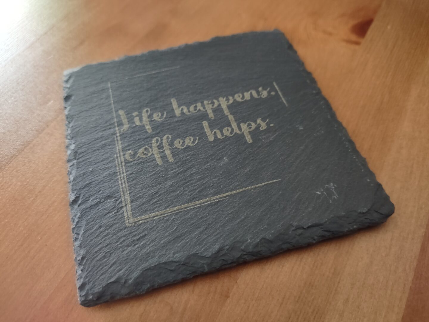 Schieferuntersetzer mit Schriftzug "Life happens, coffee helps"